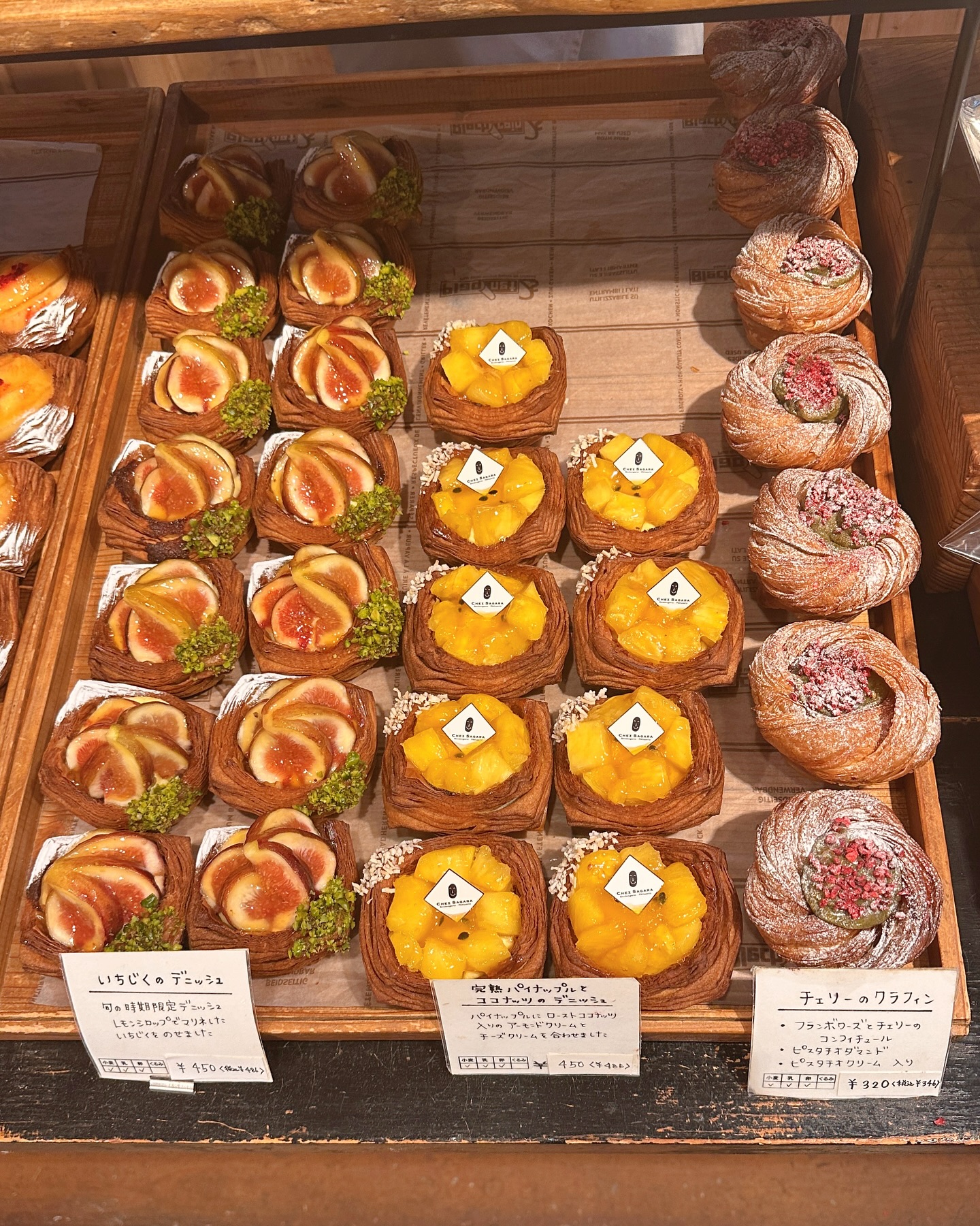 日本の福岡市のシェ・サガラさんのパンのカラフルな陳列写真。
いちじくのデニッシュ、完熟パイナップルとココナッツのデニッシュ、チェリーのクラフィンの３種類のパンが写っています。