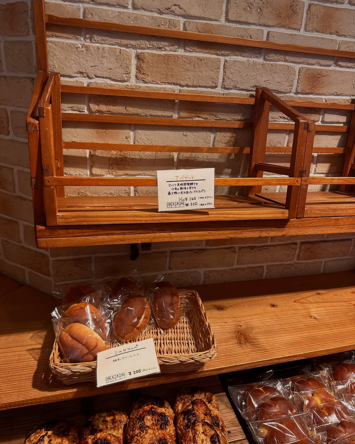 日本の福岡市のシェ・サガラさんのパンの写真。棚の上段のTバゲットは売り切れてしまいました。下段にはミルクコッペが並んでいます。