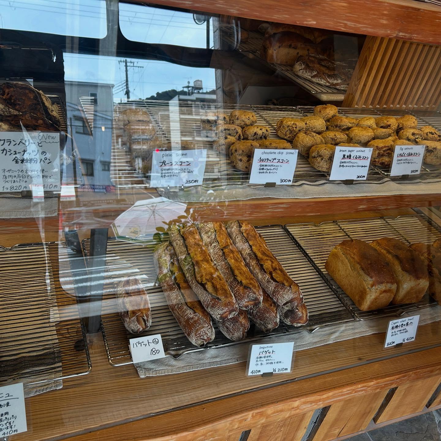 日本の兵庫県神戸市にあるベーカリー、麦秋至さんの店内の写真。アンティークな木のショーケースにパンが並んでいる。