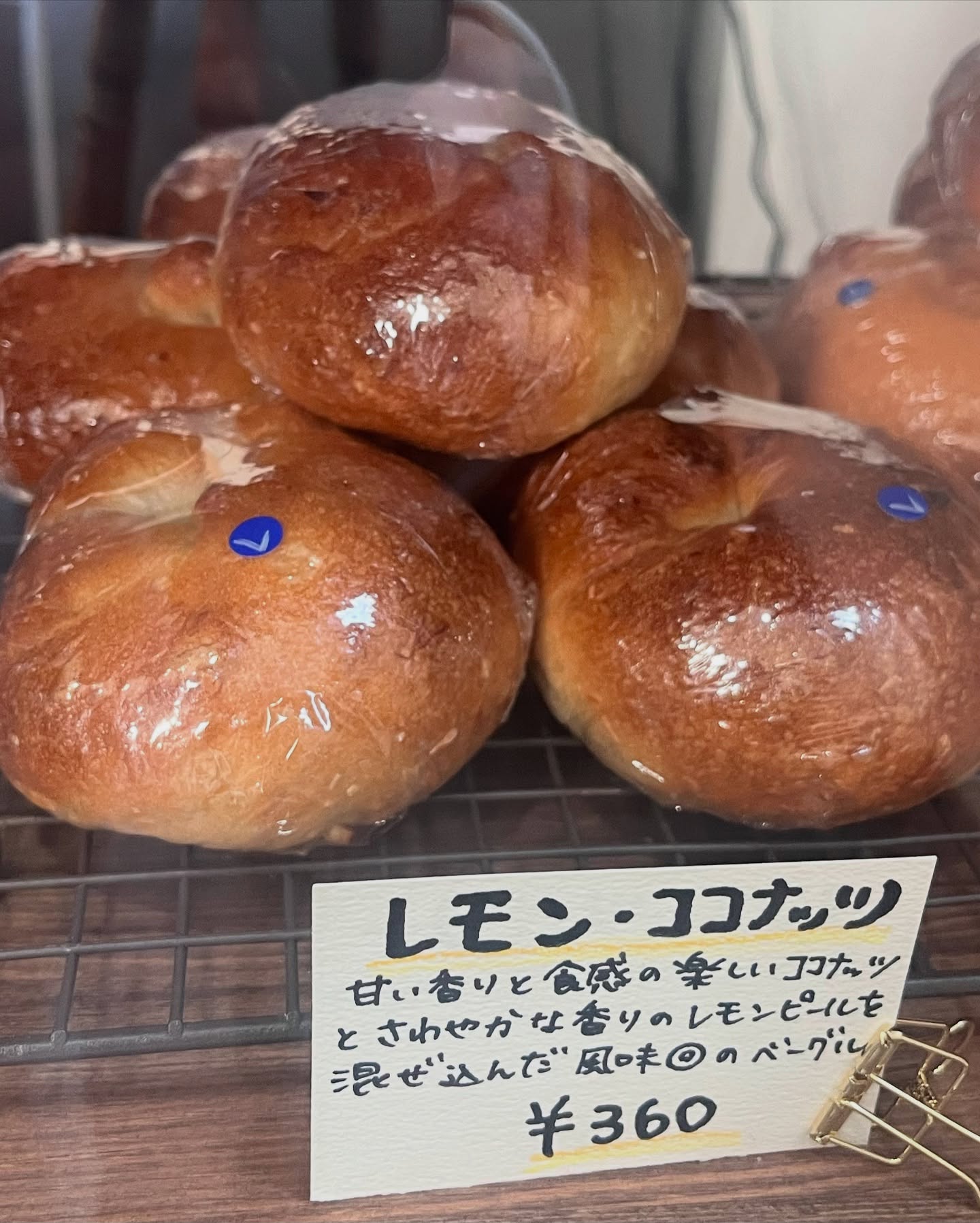 日本の東京都西新宿にあるミトウアンさんのパン。レモンココナッツのベーグルが店舗で陳列されている写真。値段は360円。