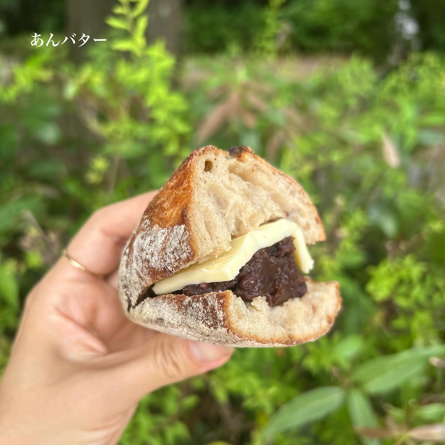 日本の兵庫県神戸市にあるベーカリー、麦秋至さんのパン。
半分の切ったあんバターを手で持っている写真。