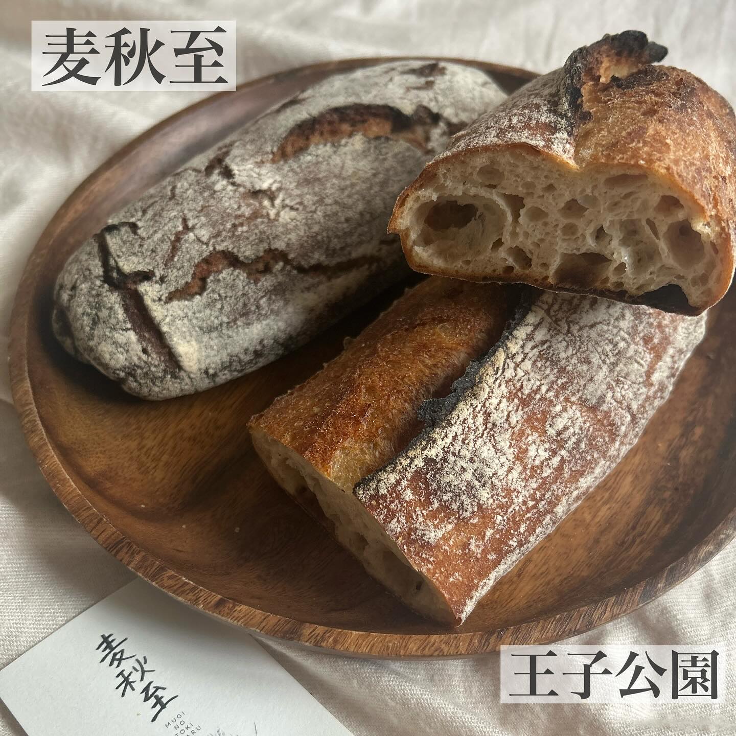 日本の兵庫県神戸市、最寄り駅は王子公園にあるベーカリー、麦秋至さんのパン。
木のお皿に載ったバゲットの写真。