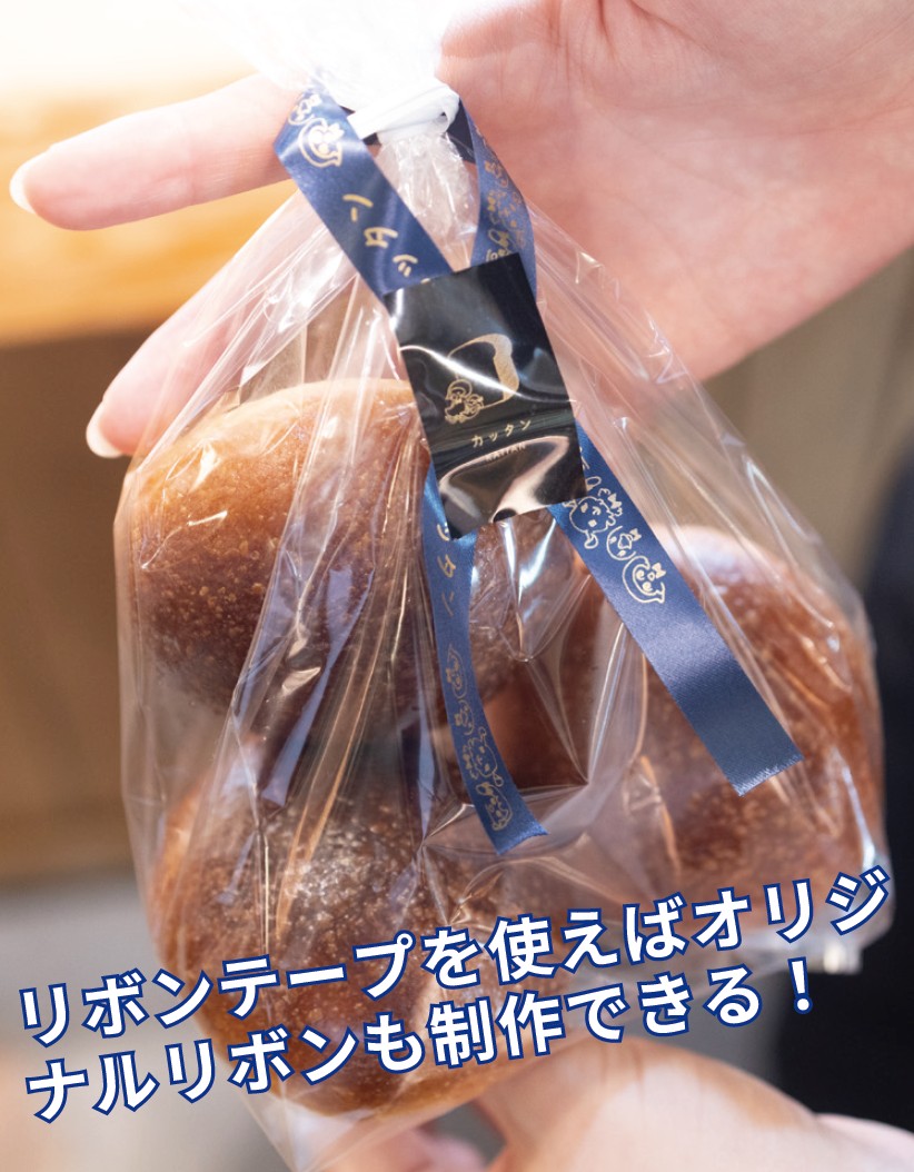 商品のパッケージにリボンをかけて、店名とロゴを印刷したラベルシールで貼り付けた例。
