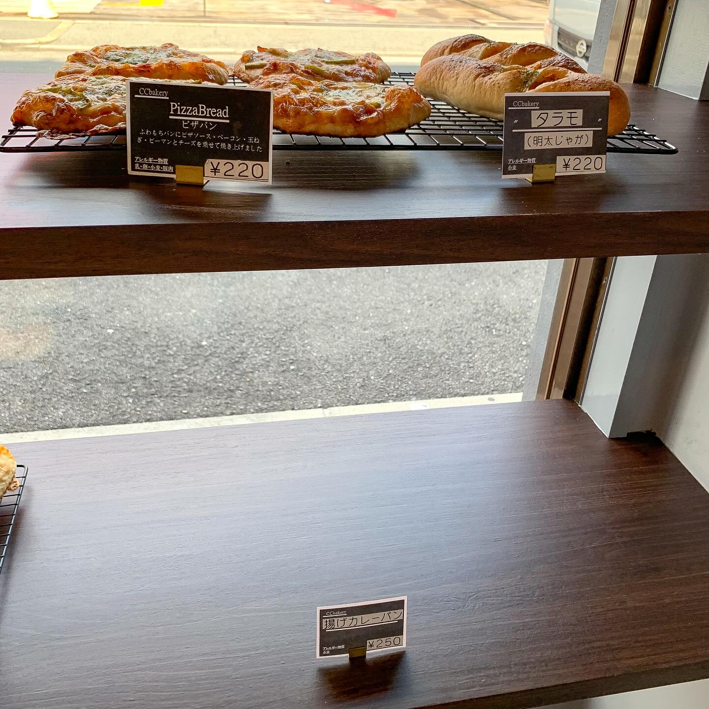 日本の大阪・西天満にあるCC Bakeryの店内写真。
棚の上段にピザパンと、明太じゃがのタラモパンが写っている