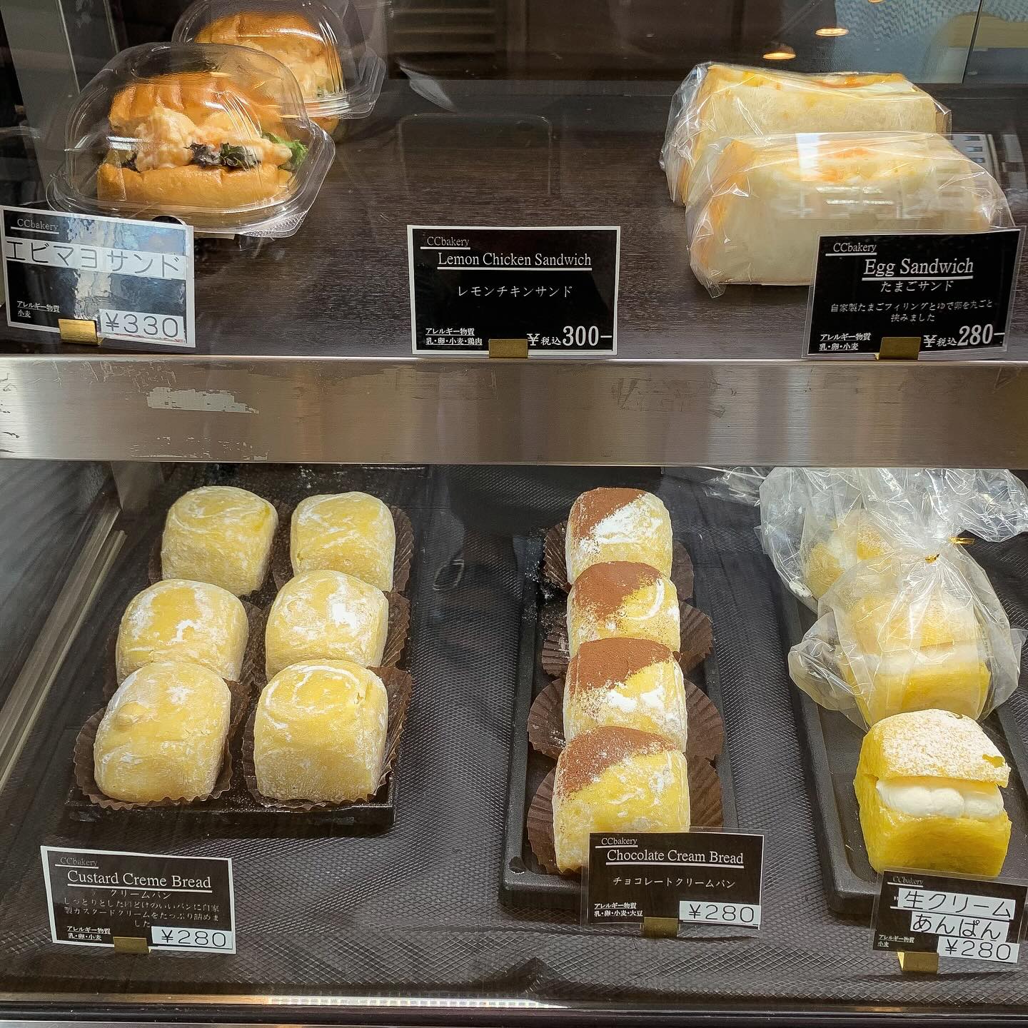 日本の大阪・西天満にあるCC Bakeryの店内写真。
ショーケース内にサンドイッチやクリームパン、チョコレートクリームパン、生クリームあんぱんといったクリームを使ったパンが並んでいる。