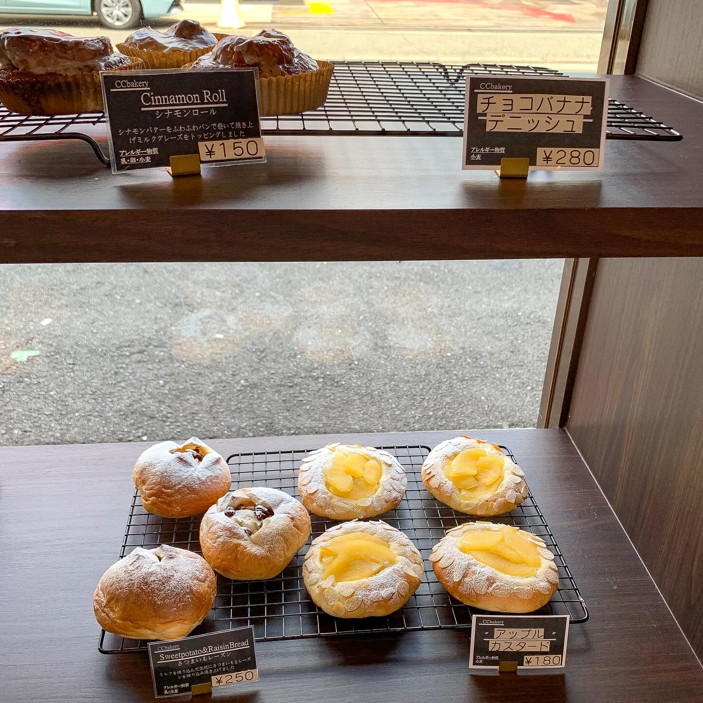 日本の大阪・西天満にあるCC Bakeryの店内写真。
棚の上段にシナモンロールが、下段にさつまいもレーズンとアップルカスタードが写っている。
上段のチョコバナナデニッシュは売り切れ。